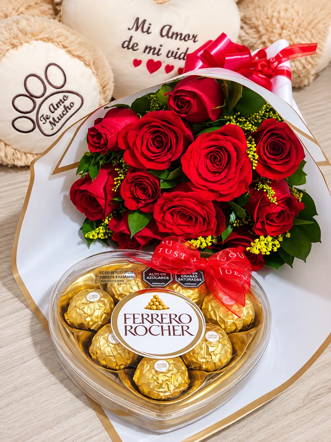 Bouquet de rosas rojas con chocolates en caja de corazón y, detrás, un oso de peluche con bordado de «Mi amor de mi vida»