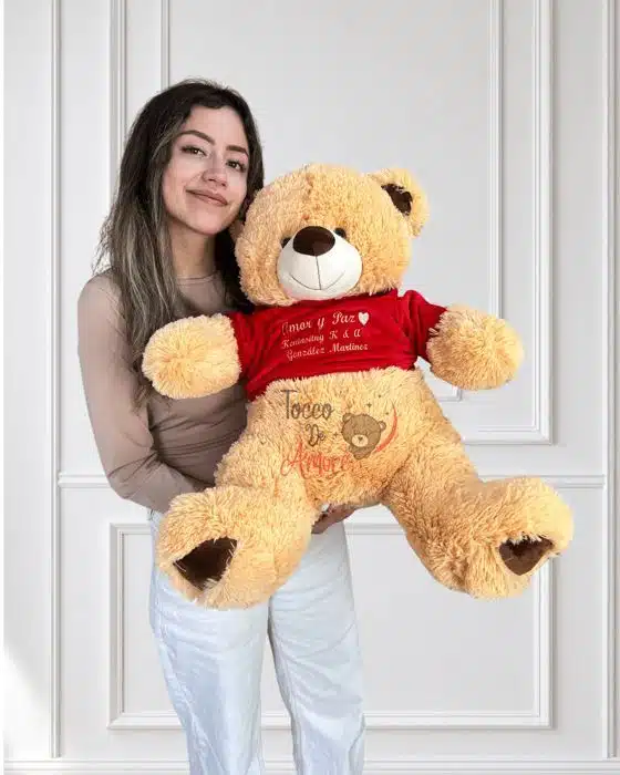 Foto real de un oso de peluche personalizado color miel con camiseta bordada, hecho por Tocco de Amore