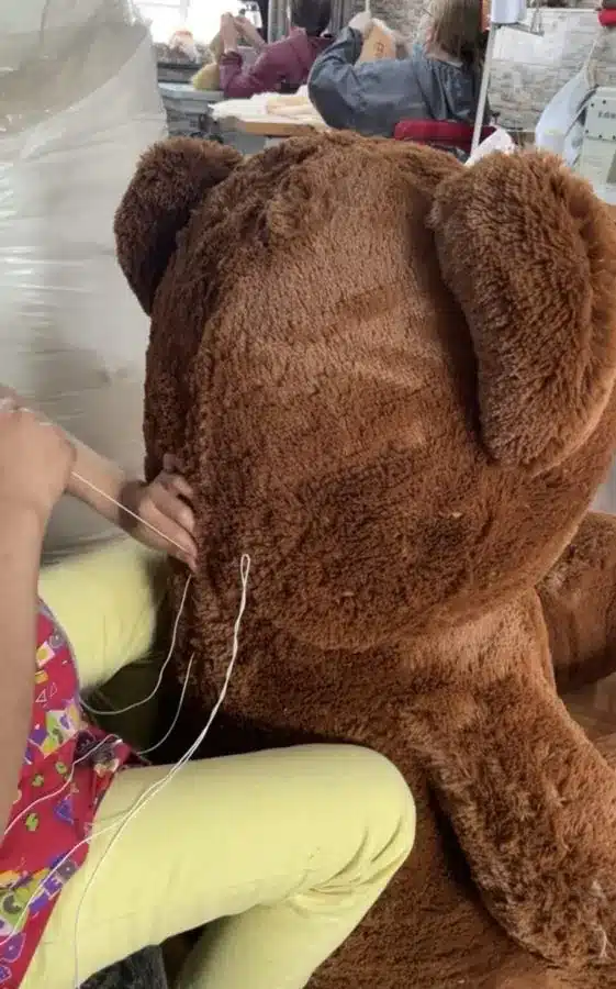 Una costurera de Tocco de Amore rellena a mano un oso de peluche gigante en el taller de Bogotá