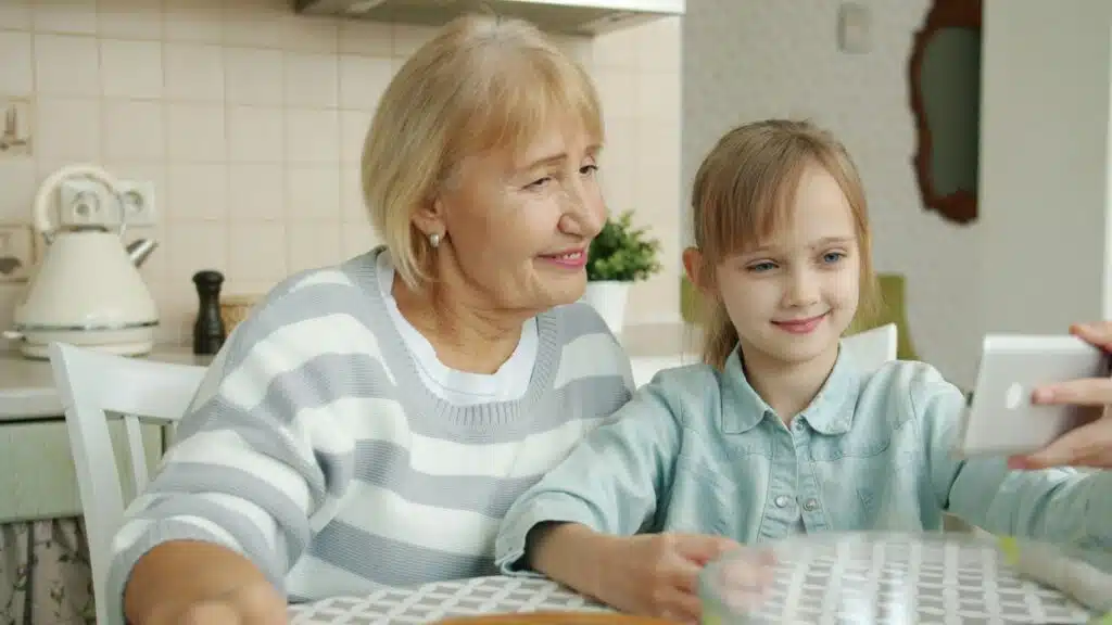 Abuela y nieta se toman una foto juntas en la cocina, un buen momento para grabar la voz de un ser querido
