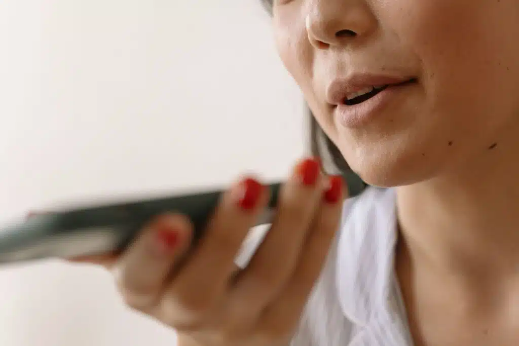 Primer plano de una mujer grabando un mensaje de voz de Navidad en el celular