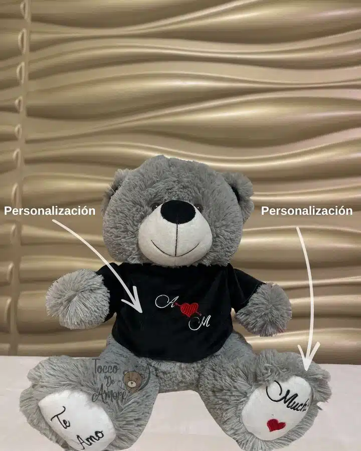 Oso de peluche gris con iniciales en la camiseta y frases bordadas en las huellas, personalizado para guardar la voz de un ser querido