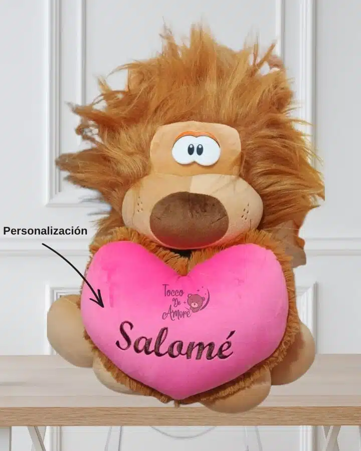 León de peluche con un corazón rosado que lleva el nombre Salomé bordado