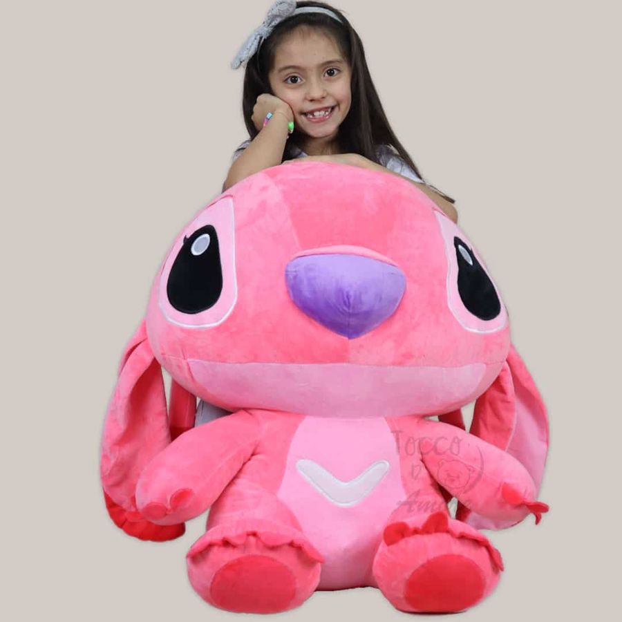 Niña con un peluche de Stitch rosado de 60 cm